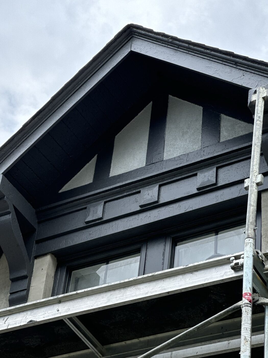 Finished stucco panels between black half-timber boards on a Tudor gable in Toronto