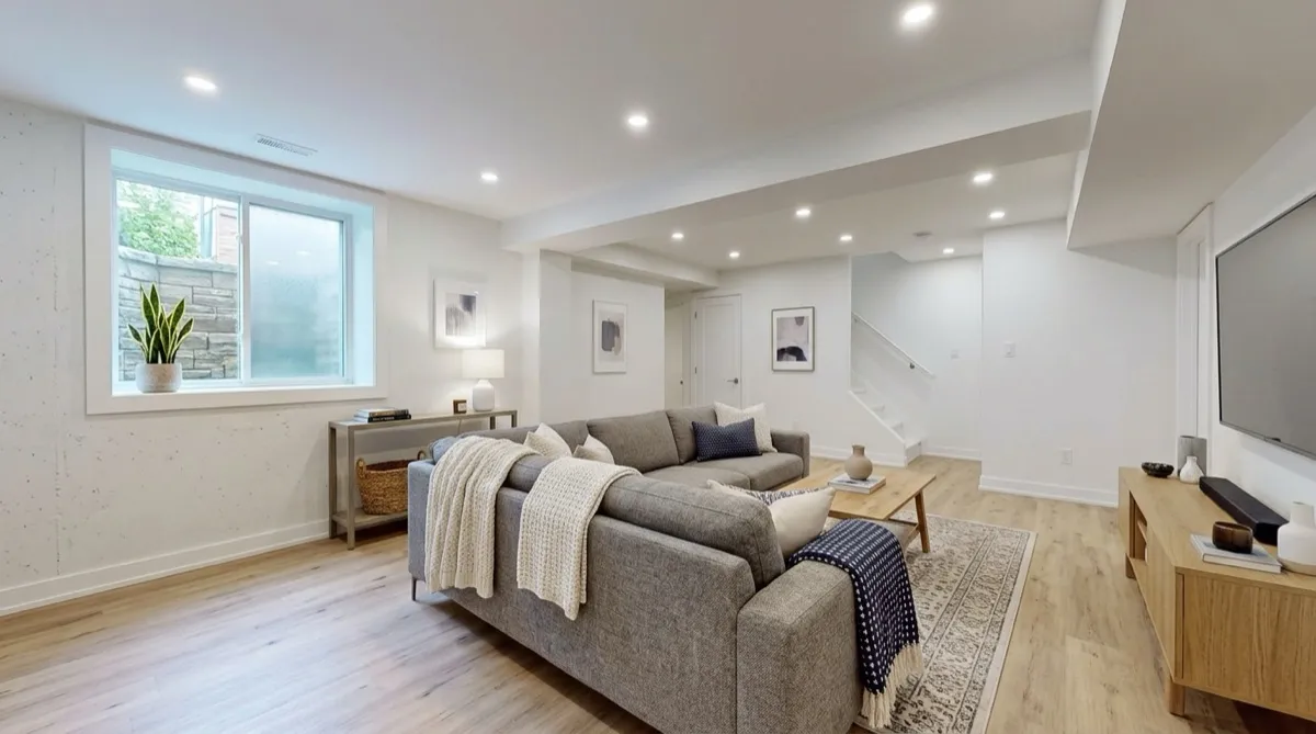 Bright finished basement family room in a Toronto home with pot lights and vinyl plank floors